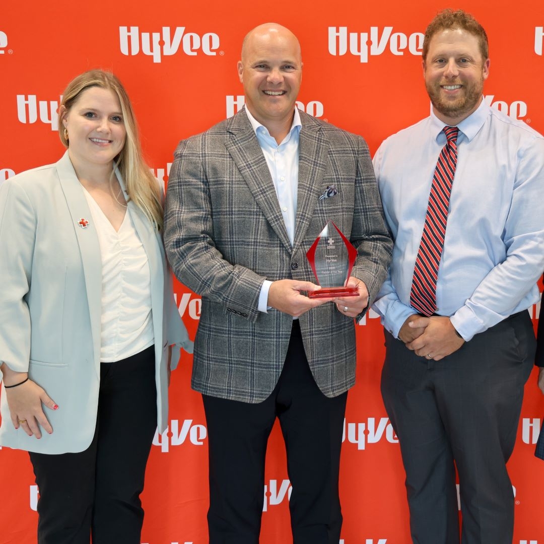 man holds award between two other people