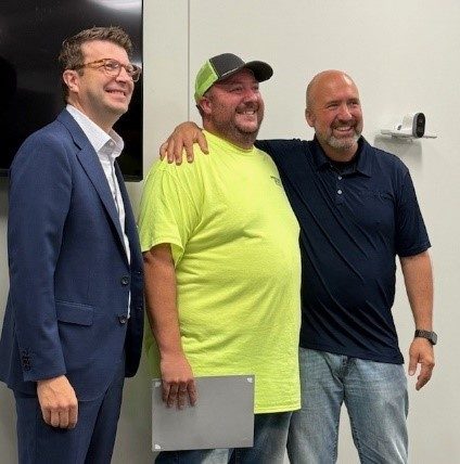 three men with arms around each other