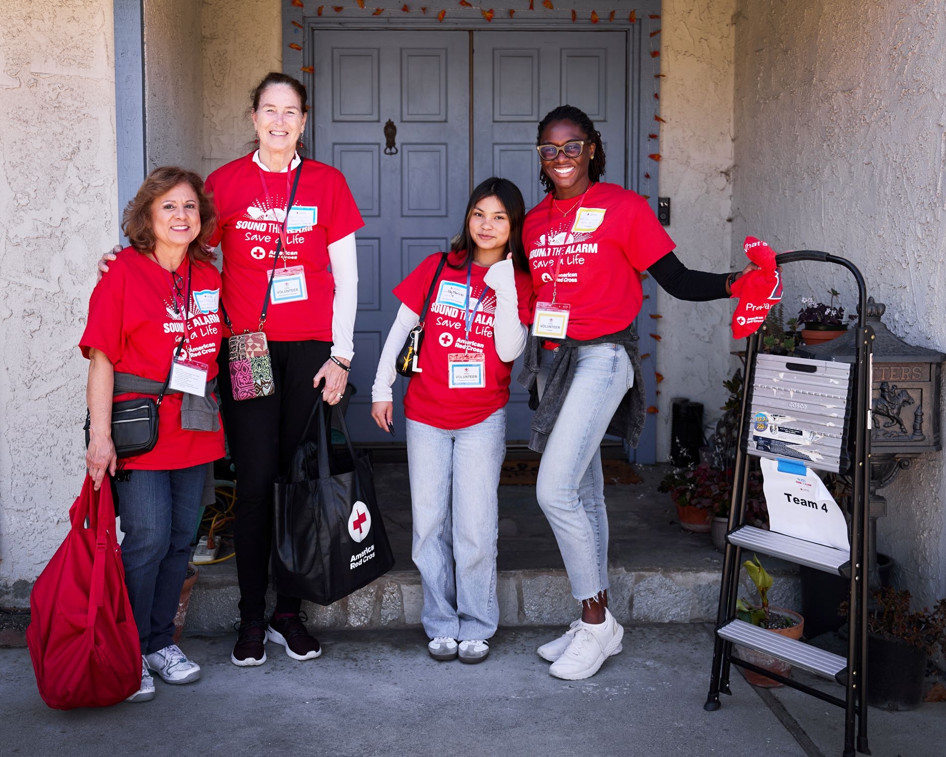 4 sound the alarm volunteers standing outside of front door.