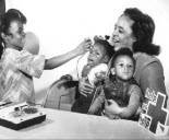 Old black and white photo showing Red Cross volunteer assisting a military family