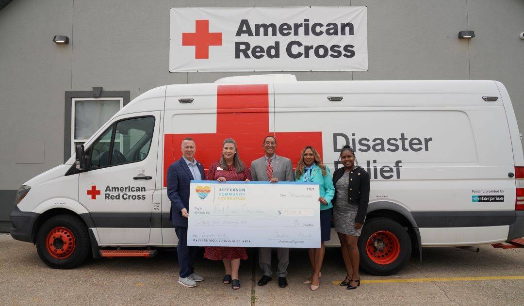 Image of people holding large check in front of Red Cross response vehicle