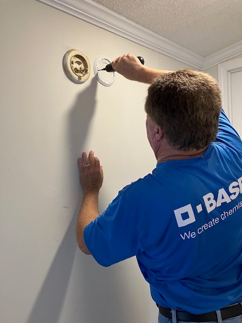 red cross volunteer in blue shirt installing smoke alarm