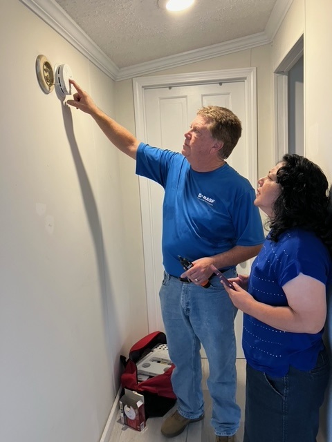 red cross volunteer instaling smoke alarm