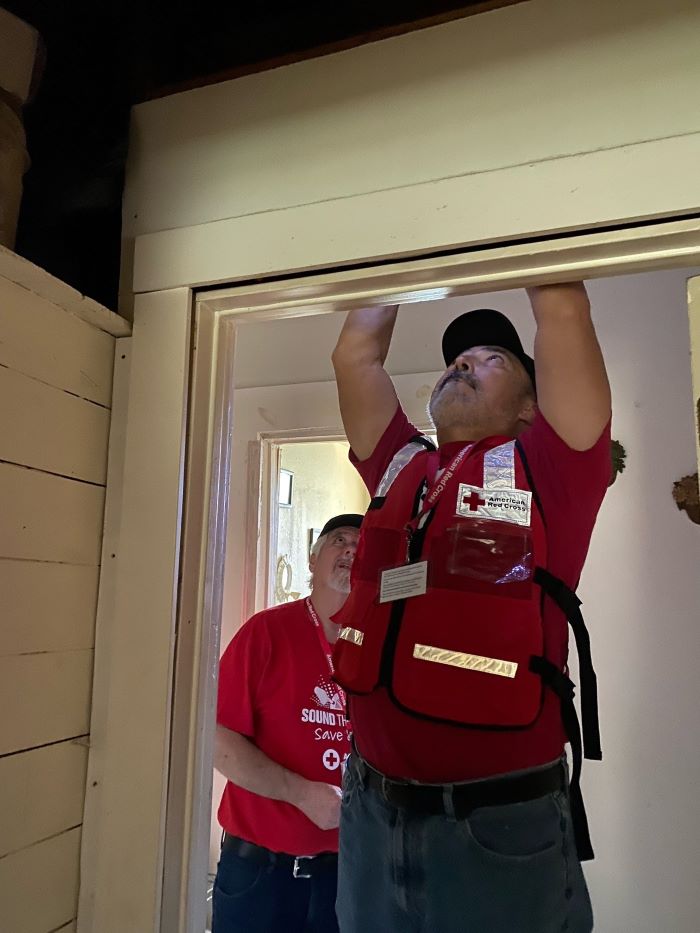 red cross volunteer frank installing smoke alarm