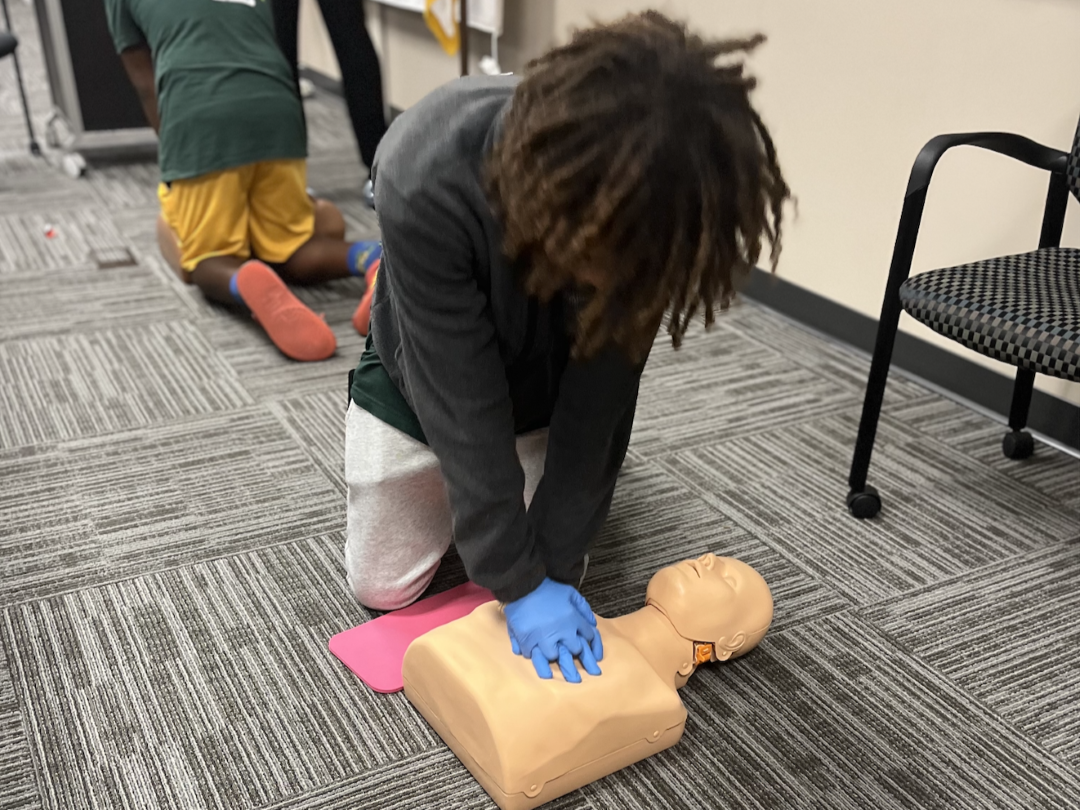Youth practices CPR on mannequin