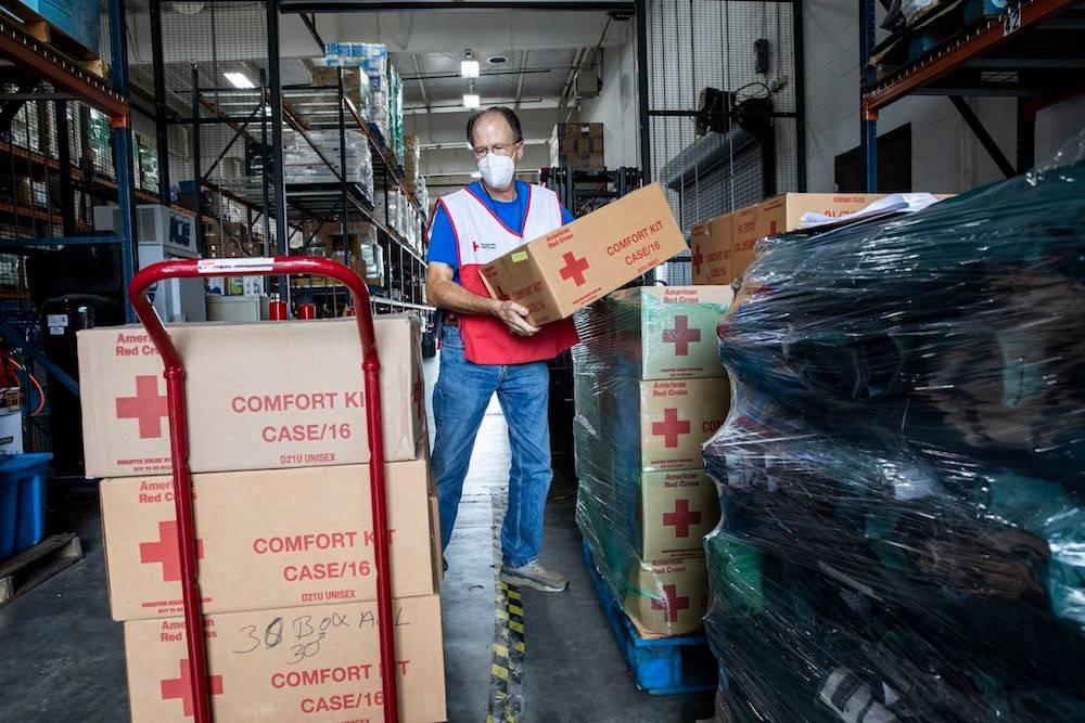 August 28, 2021. Baton Rouge, Louisiana. Red Cross volunteer Don Meyn, of Baton Rouge, stacks crates of comfort kits that will be loaded onto trucks and shipped to nearby emergency shelters in preparation for Hurricane Ida. 

Hurricane Ida is expected to be an extremely dangerous Category 4 storm as it makes landfall along the Gulf Coast on Sunday. By Saturday afternoon, some 450 Red Cross volunteers were on the ground ready to open shelters and support people who need a safe place to stay. Hundreds more volunteers are also being mobilized to support relief efforts after landfall. In addition to pre-positioned supplies, the Red Cross is moving additional truckloads of cots, blankets, comfort kits, and ready-to-eat meals. Photo by Scott Dalton/American Red Cross
