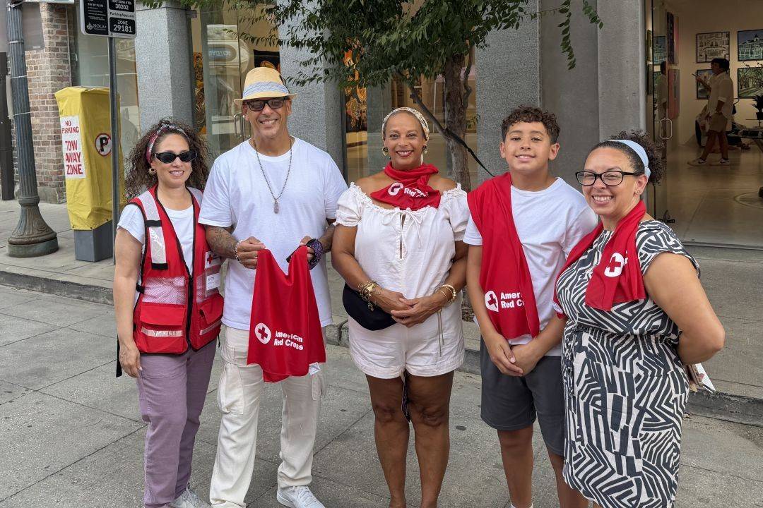 Group of people stand holding Red Cross towels