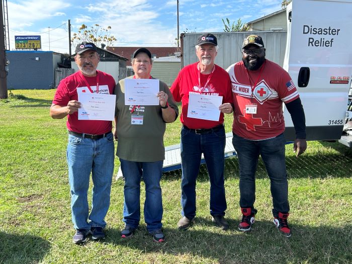 four red cross volunteers holding awards smiling