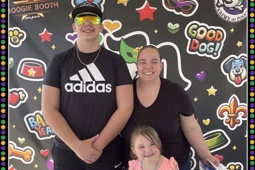 Woman stands with two children in photo booth