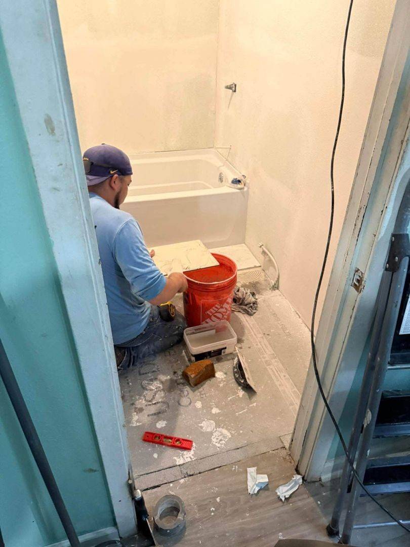 Man works on remodeling a bathroom