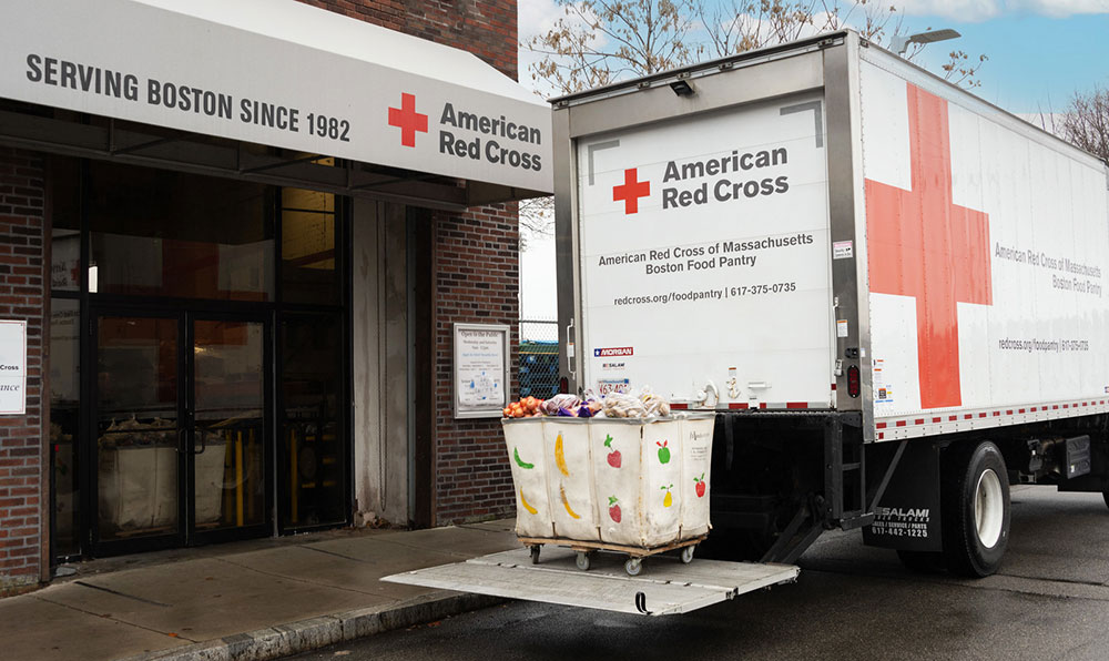 American Red Cross delivery truck with a cart full of food on it's liftgate.