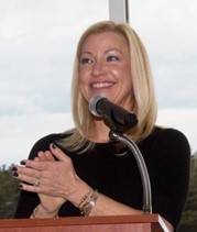 woman smiling in black dress at podium 