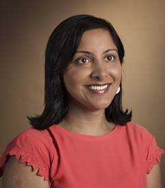 woman with black hair smiling in red shirt 