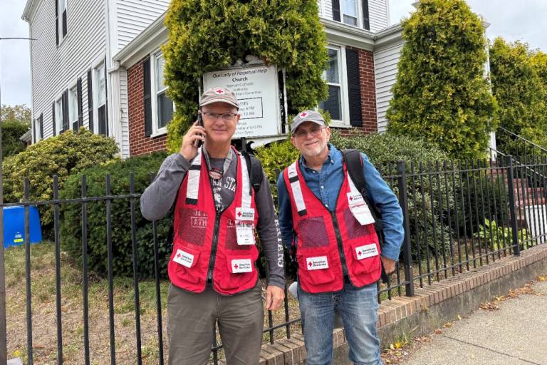 Two Red Cross volunteers stand outside