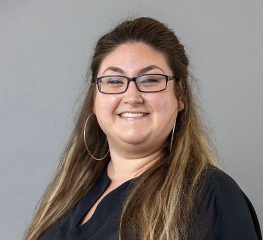 woman smiling in black shirt wearing glasses