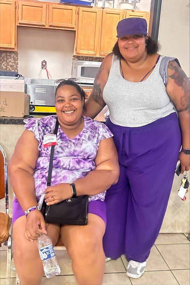 Two women smile at the camera after donating blood