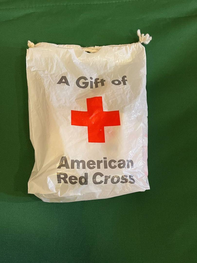 Comfort kit bag lays on Red Cross cot