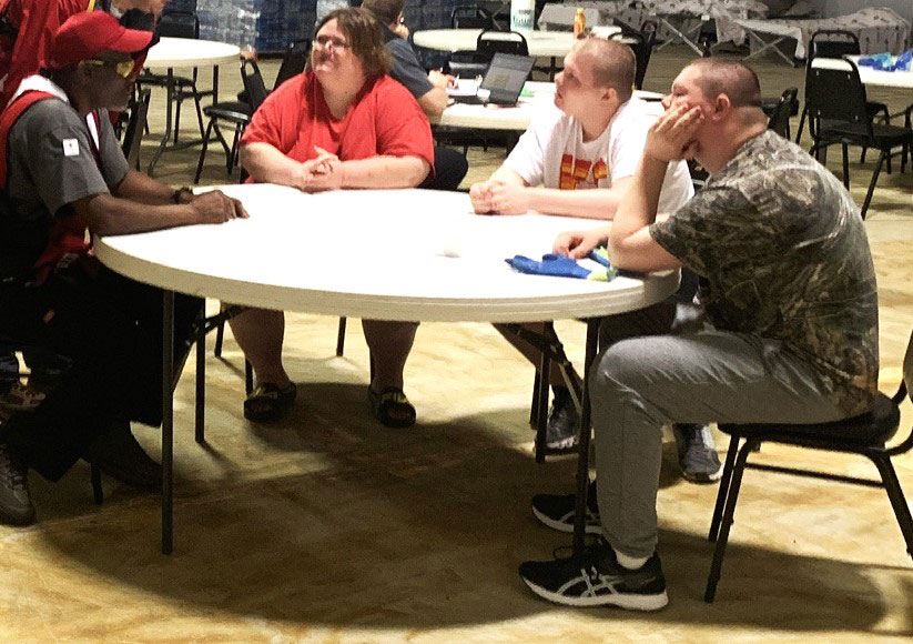 Jennifer Wolfe and her sons talk to Red Cross volunteer at the Red Cross shelter