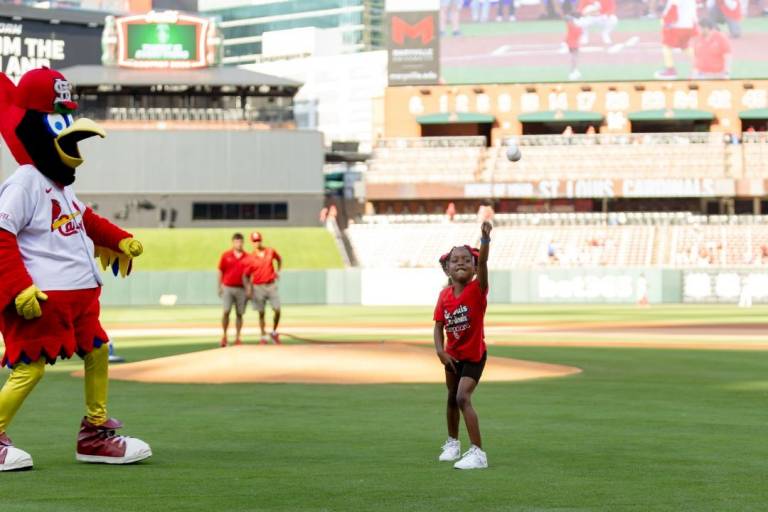 Young girl throws first pitch at baseball game