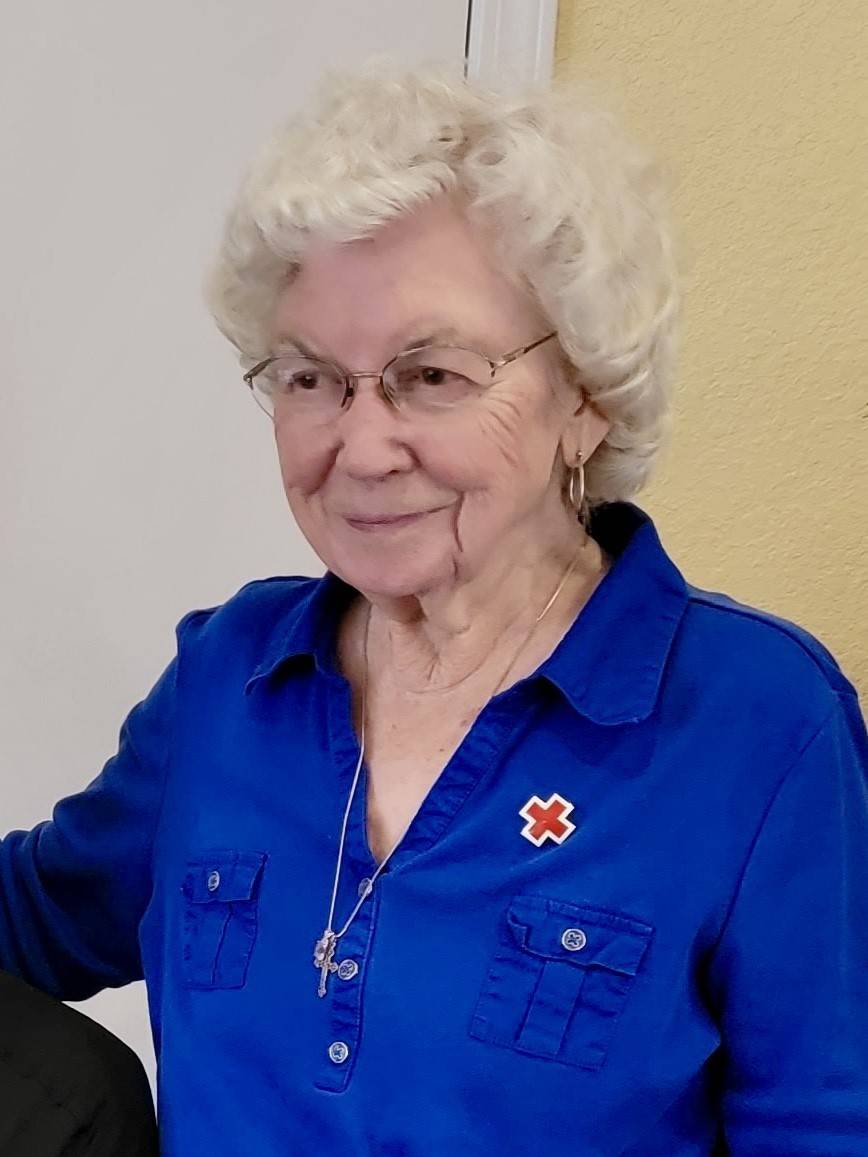 Image of woman in blue shirt with Red Cross pin