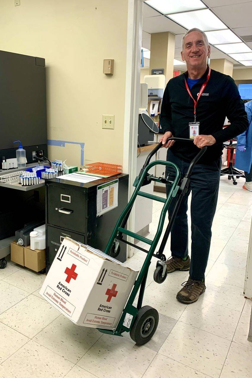Man wheeling box of donated blood