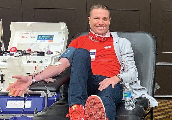 Man smiles while donating blood
