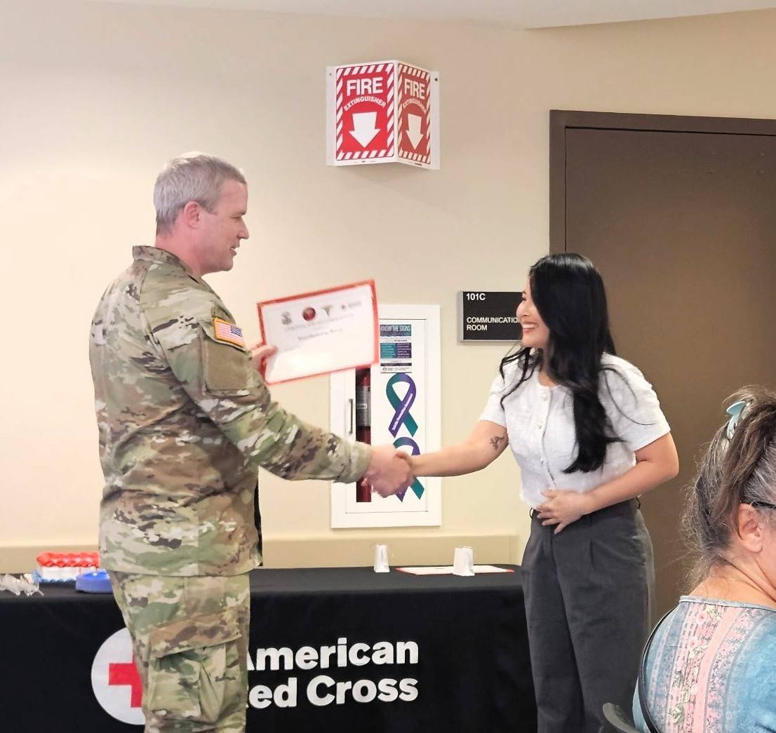 Woman shakes hand with service member