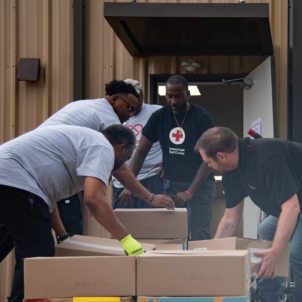 five red cross volunteers helping sort items