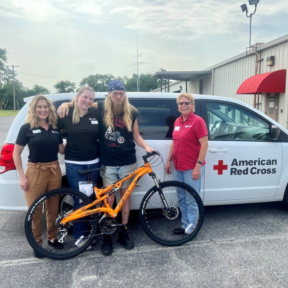 Red Cross staff with vetaran and new bike