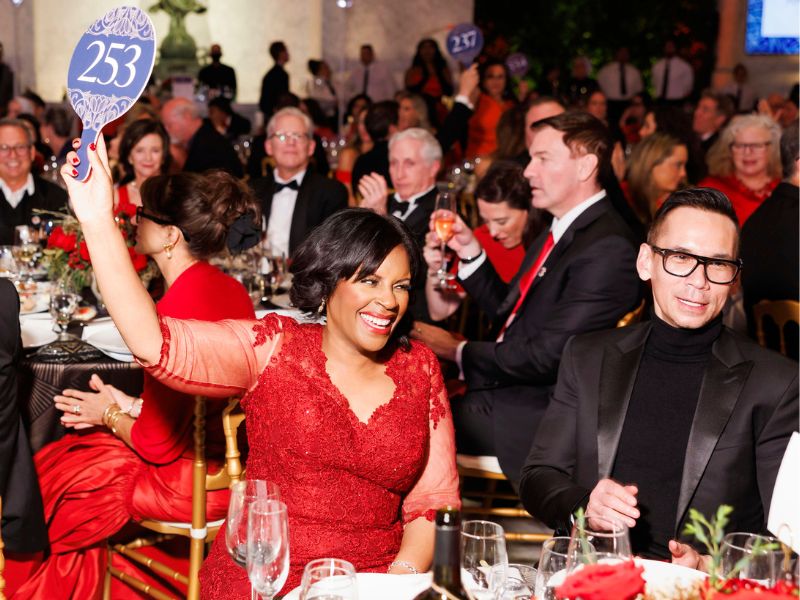 gala attendee holding an auction sign up at group table