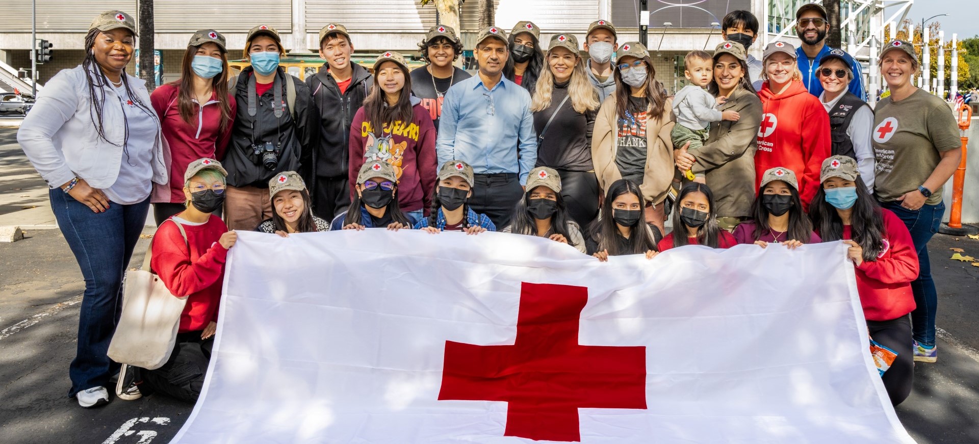 A group of people holding a red cross flag