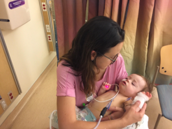 Sarah holding a baby in the hospital.
