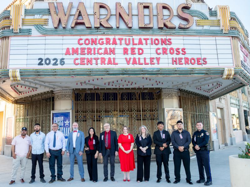 group of heroes stand at the entrance of warnors theater