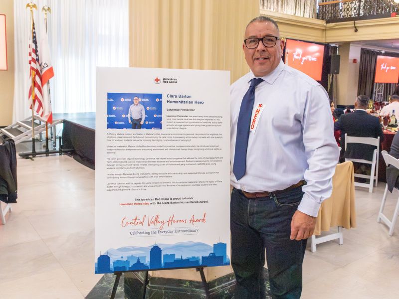 man standing next to humanitarian hero poster