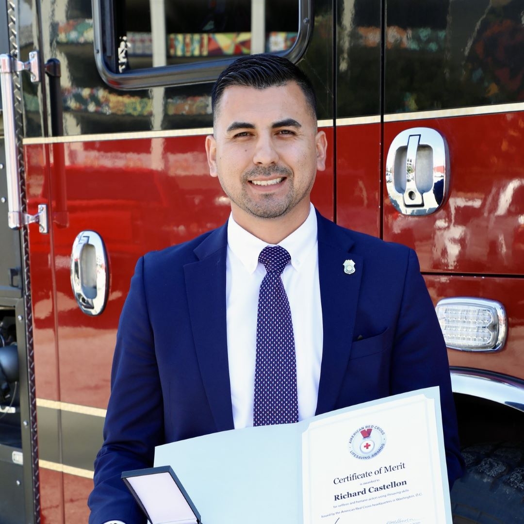 man standing holding lifesaving award