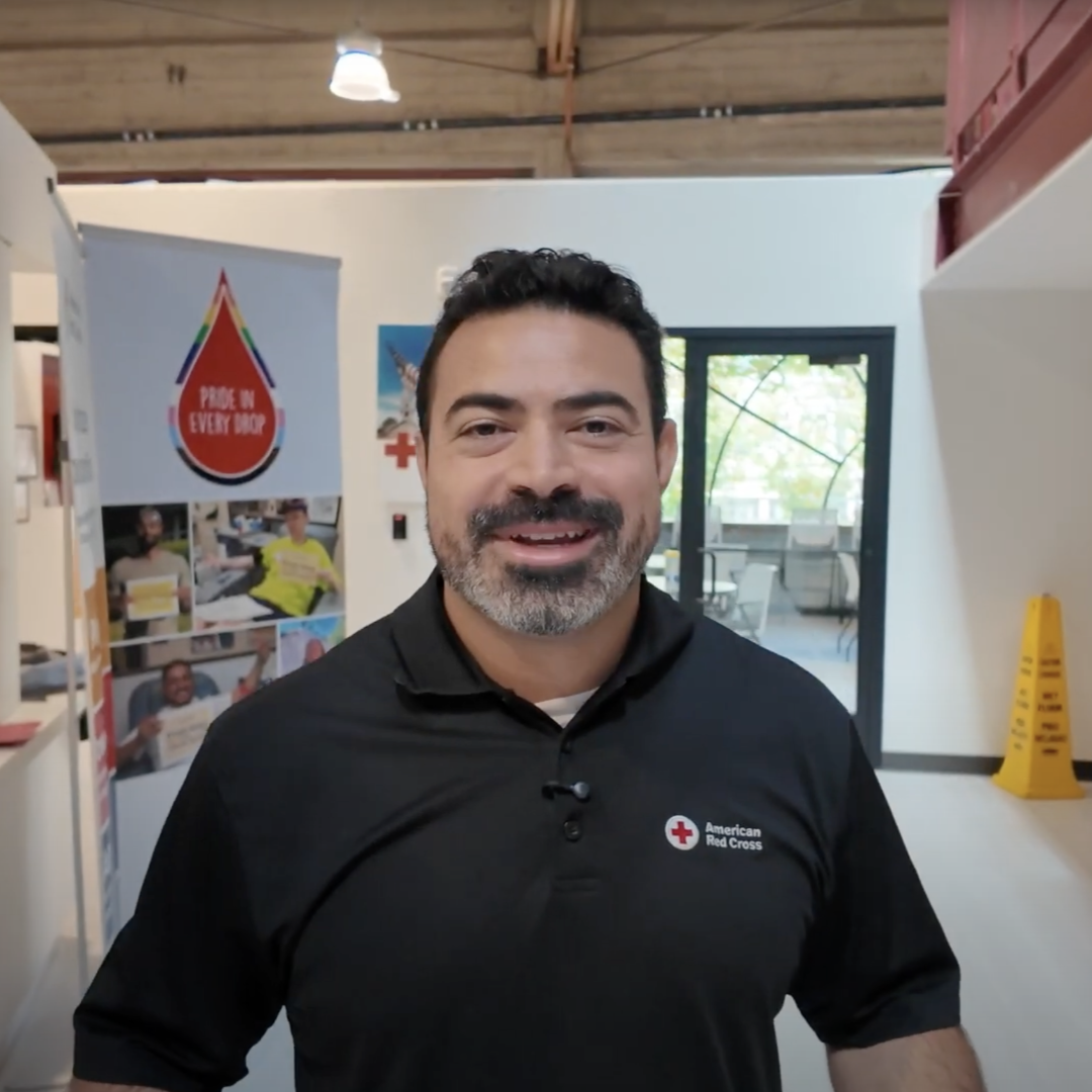 man in red cross shirt smiling