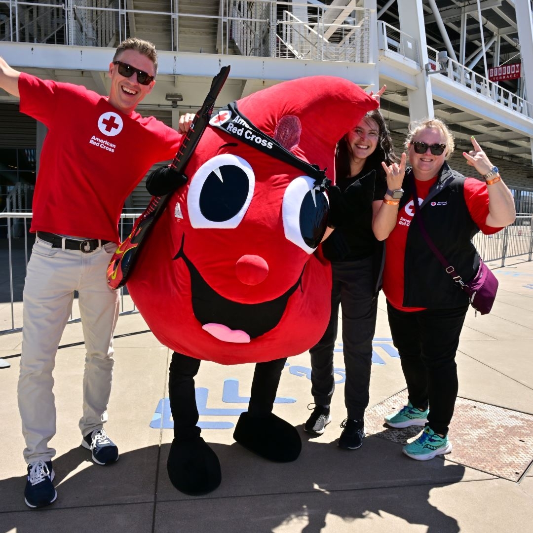 smiling people posing with blood drop mascot