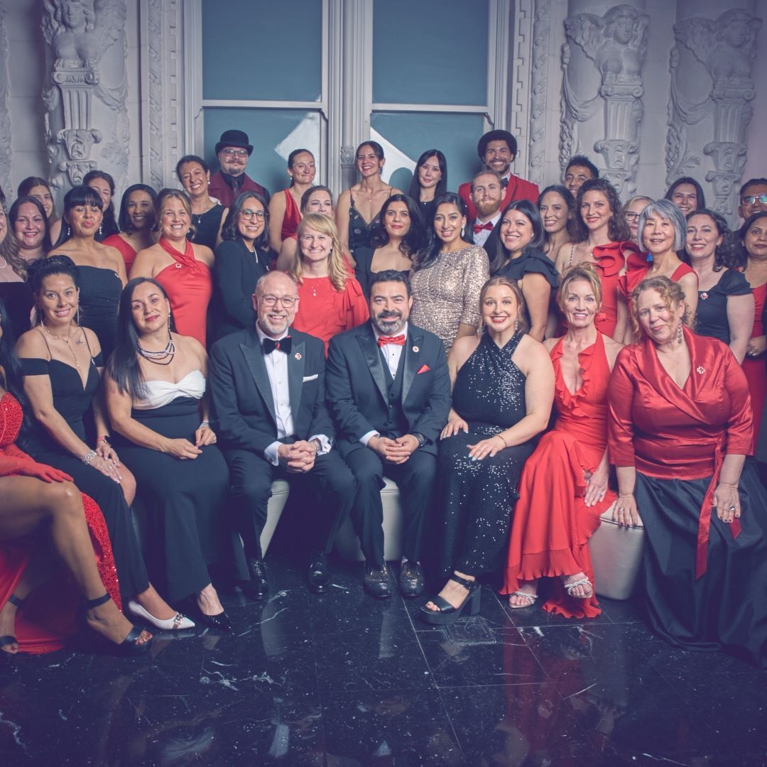 group of people in suits and dresses at gala