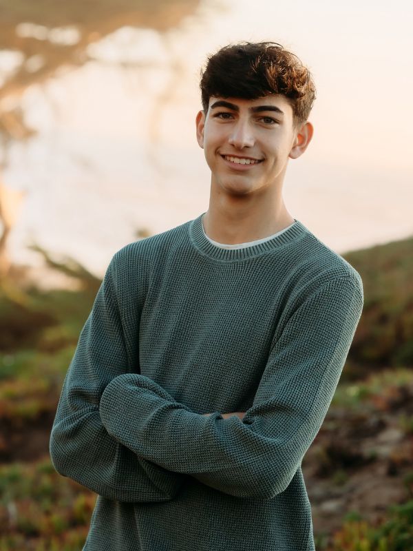 young man in green shirt with arms folded