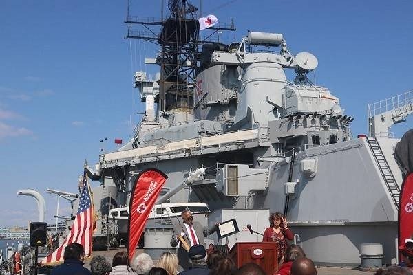 Two people at a podium on the Battleship New Jersey