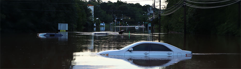 white car submerged in flood water.
