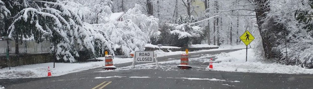 Road closed sign on a snowy road.