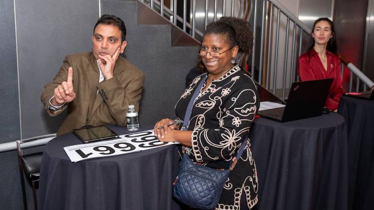 A man and a woman at a table participating in an auction.