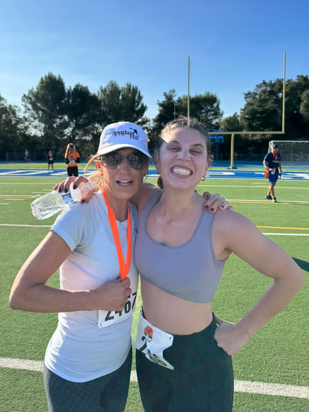 Missy Romoff, with another person on a football field, wearing running gear.