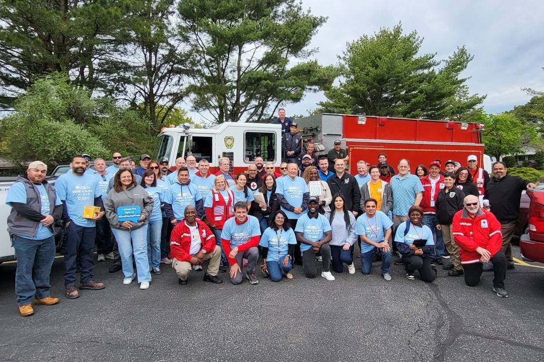 Group of people stand in front of fire truck