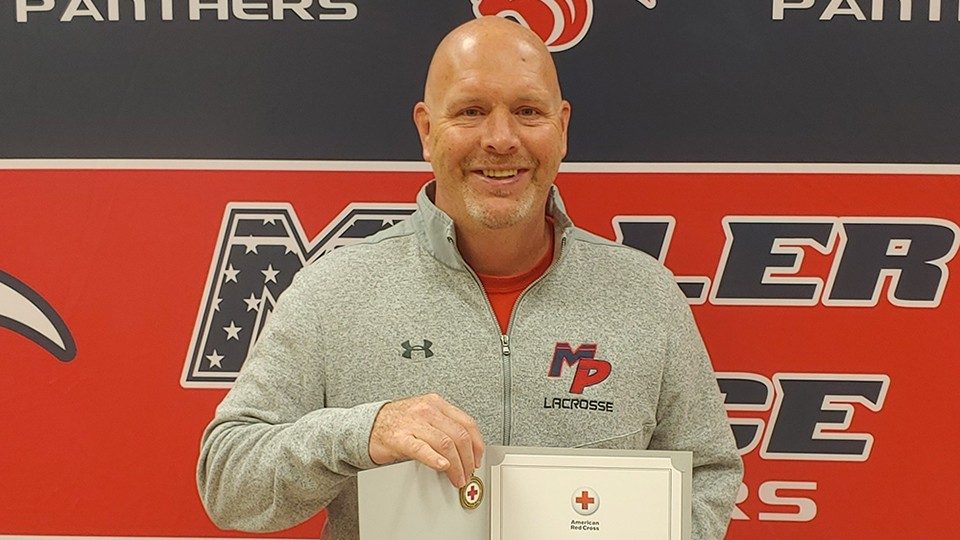 Ron Petrie holding and displaying his Red Cross Certificate of Merit.