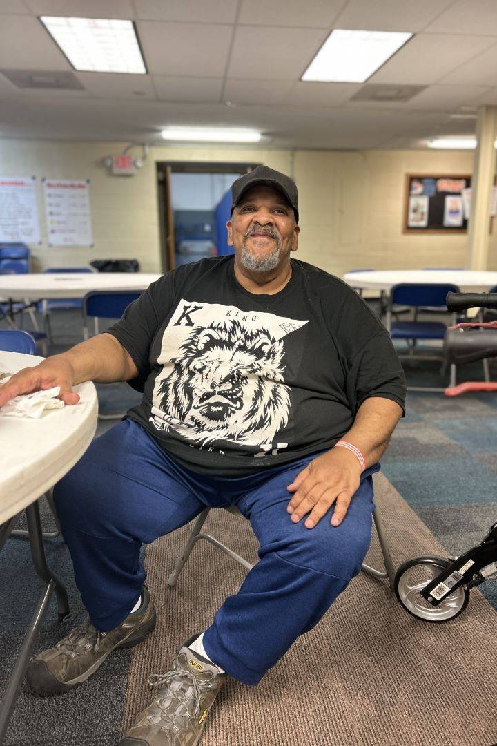 Man sits at table inside Red Cross shelter
