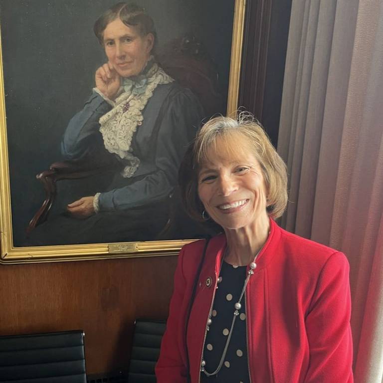 Sue standing next to a portriat of Clara Barton