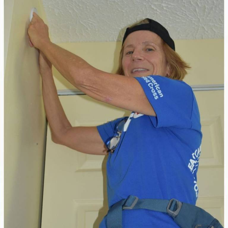 Sue installing a smoke alarm