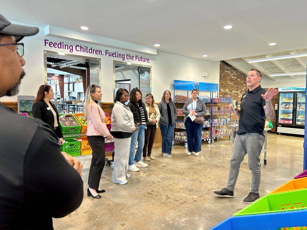 A person standing giving directions to a group of people listening